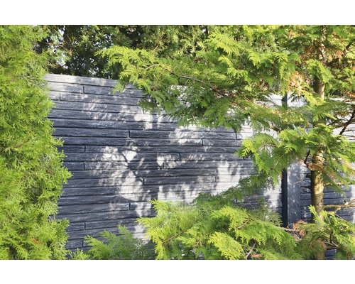 Dekorative Gartenmauer aus Stein mit Pflanzen im Vordergrund