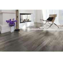 Heller Wohnraum mit Laminatboden in Holzoptik, Kamin und Sessel