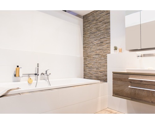 Helles Badezimmer mit Badewanne, Waschtisch und Wandfliesen