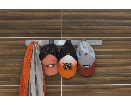 Hakenleiste mit Mütze und Schal vor einer Holzwand