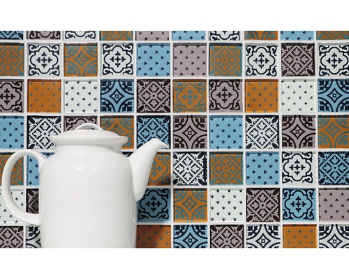 Dekorative Mosaikfliesen mit Mustern und eine weiße Teekanne