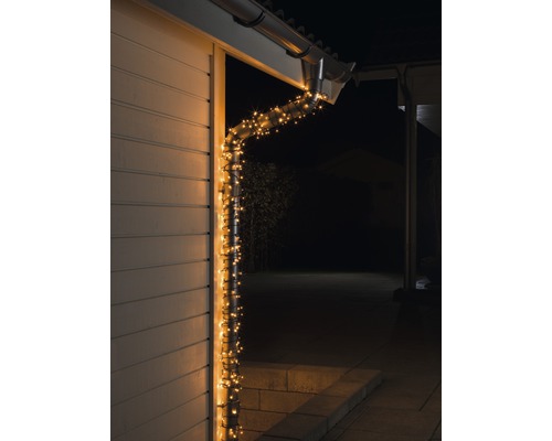 Micro LED Lichterkette Konstsmide 12,64 m + 10 m Zuleitung 80 LEDs bernstein Beleuchtete Regenrinne an einem Haus bei Nacht
