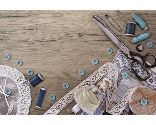 Nähszene mit Schere, Knöpfen, Garnspulen, Sicherheitsnadeln und Spitze