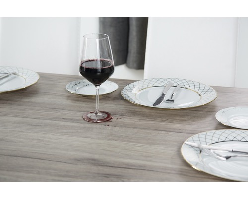 Gedeckter Tisch mit Weinglas, Tellern und Besteck