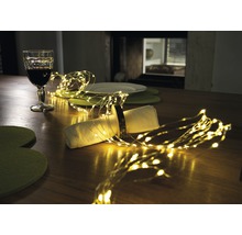 Tischdekoration mit Lichterkette, Glas und Geschirr