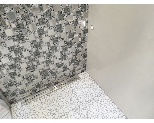 Badezimmer mit Mosaikwand, Bodenfliesen in Kieselsteinoptik und Ablaufrinne