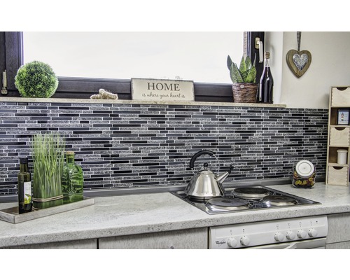 Küchenszene mit Mosaikfliesen, Edelstahlkessel und dekorativen Elementen.