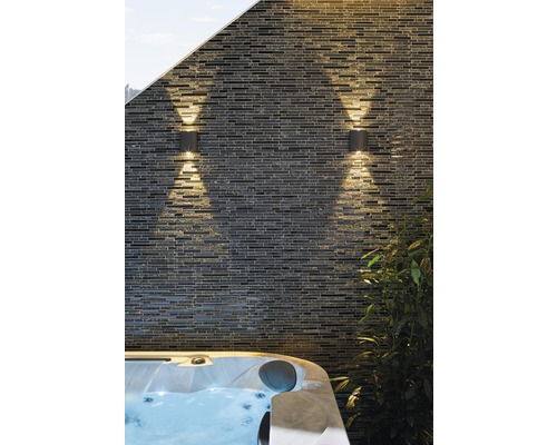 Zwei Aussenleuchten an einer Steinwand neben einem Whirlpool