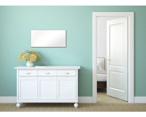 Wohnraum mit weißer Kommode, Spiegel und offener Tür