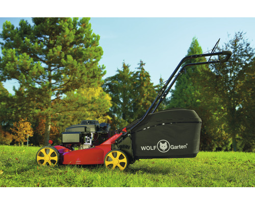 Wolf Garten Rasenmäher auf Rasen vor Bäumen