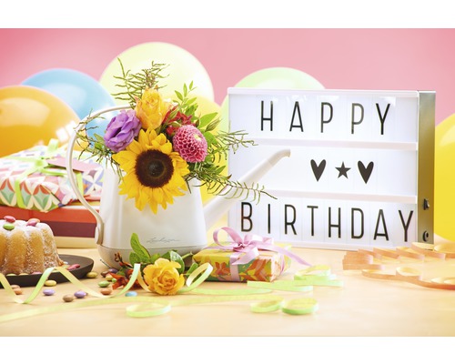 Dekoratives Geburtstagsarrangement mit Gießkanne, Blumen, Geschenken und Lichtbox