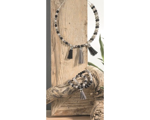 Halskette und Armband mit Quasten auf Holzuntergrund