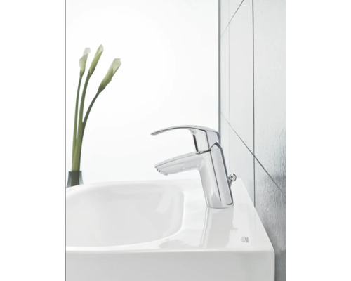 Waschtischarmatur auf einem Waschbecken mit Blumenvase