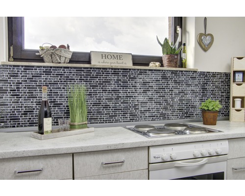 Küchenszene mit Mosaikfliesenwand, Herd und Dekorationen auf der Arbeitsplatte.