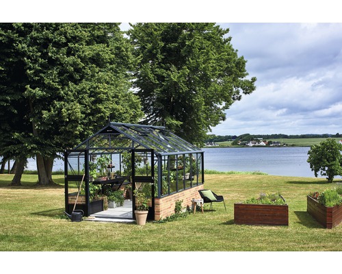 Gewächshaus im Garten mit Pflanzen und Hochbeeten