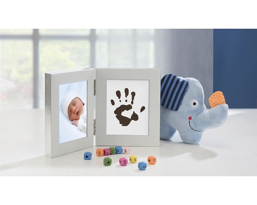 Doppelter Bilderrahmen mit Babyfoto und Handabdruck, begleitet von einem Stoffelefanten und Spielwürfeln