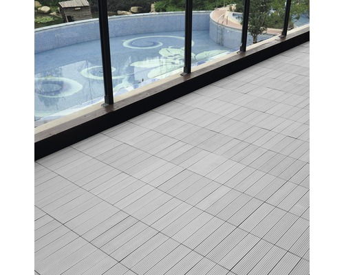 Verlegte Terrassenfliesen auf einem Balkon mit Blick auf einen Pool