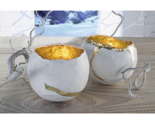Zwei dekorative Schalen mit Goldakzenten und Zweigen auf einem Tisch