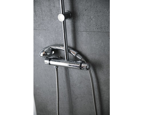 Brausethermostat mit Kopfbrause und Handbrause an einer grauen Wand