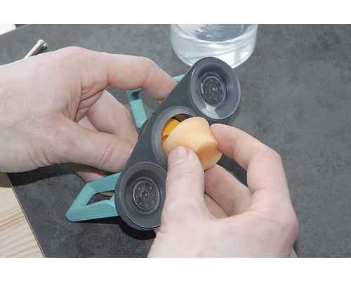 Reinigung eines Fensterreinigers mit Saugnäpfen und Schwamm