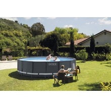 Intex Pool im Garten mit badenden Personen und Gartenmöbeln