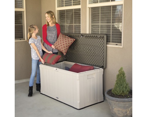 Szene mit Mutter und Tochter, die Kissen in eine Aufbewahrungsbox im Freien legen