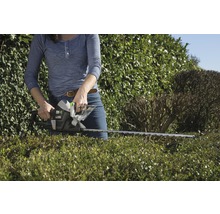 Frau schneidet Hecke mit einer Heckenschere der Marke for_q.
