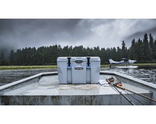 Kühlbox auf einem Boot mit Angelruten und einem Wasserflugzeug im Hintergrund