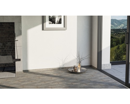 Heller Raum mit Steinboden, Grillplatz und Terrassentür zum Garten