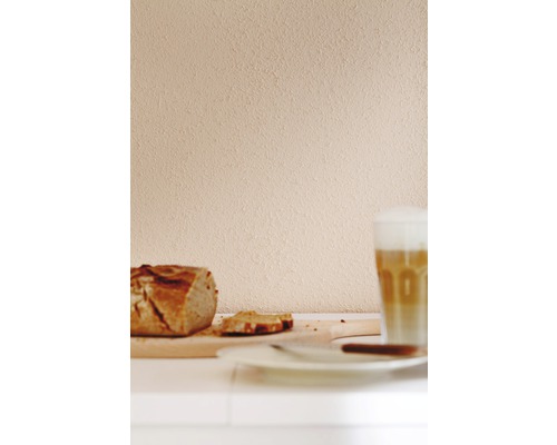 Stillleben mit Brotlaib, Brotscheiben und Latte Macchiato auf einem Tisch.