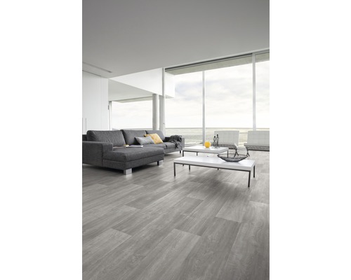 Wohnzimmer mit grauem Vinylboden in Holzoptik, Sofa und Couchtischen.