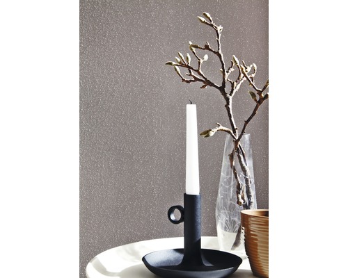 Dekorative Szene mit Kerzenständer, Kerze und Vase auf einem Tisch vor einer strukturierten Wand