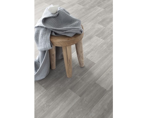 Szene mit Vinylboden in Holzoptik und einem Hocker mit Strickdecke