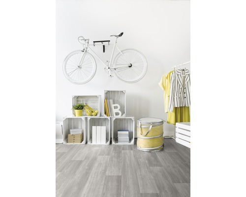 Heller Raum mit weißem Fahrrad an der Wand, Holzkistenregal und grauem Bodenbelag