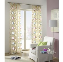 Dekorativer Vorhang mit Kreismuster vor einem Fenster in einem Wohnzimmer.