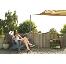 Frau entspannt auf einem Outdoor-Sessel auf der Terrasse mit Sichtschutzwand und Sonnensegel
