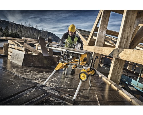 Tischkreissäge im Einsatz auf einer Baustelle mit Holzbalken und Bauarbeiter