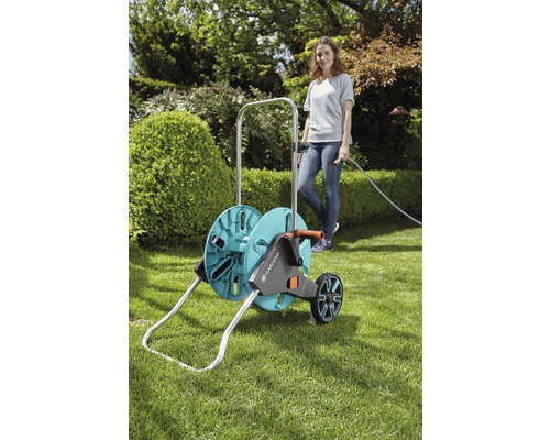 Gartenschlauchwagen mit Schlauch und Frau im Garten