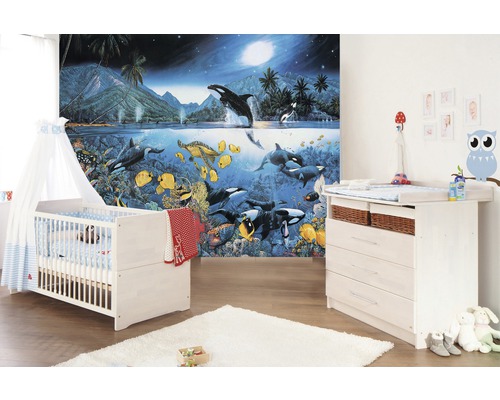 Kinderzimmer mit Gitterbett, Wickeltisch und Fototapete mit Meeresmotiven