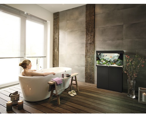 Badezimmer mit freistehender Badewanne, Aquarium und Holzfußboden für eine entspannende Atmosphäre