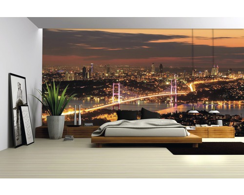 Schlafzimmer mit Fototapete einer nächtlichen Stadtansicht mit Brücke