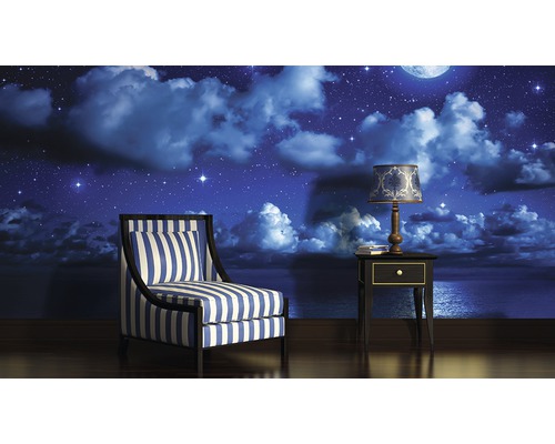 Wohnzimmer mit Sessel, Nachttisch und Fototapete mit Nachtmotiv