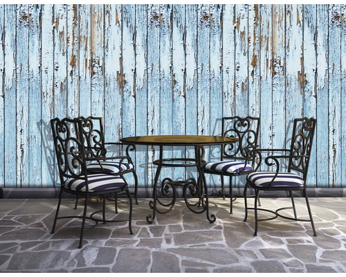 Szene mit Gartentisch, vier Stühlen und einer Wand mit blätternder Farbe