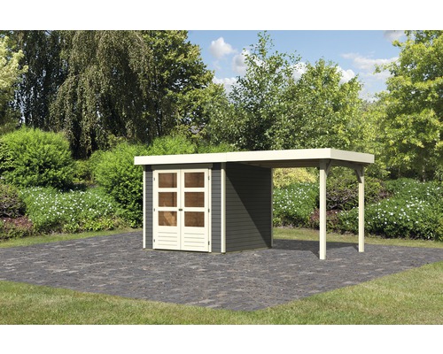 Gartenhaus Karibu Kodiak 2 mit Anbaudach 2,8 m 521 x 238 cm terragrau Gartenhaus mit Anbau auf gepflasterter Fläche vor grünem Hintergrund
