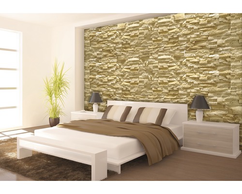 Schlafzimmer mit Steinwand, Bett und Nachttischen.