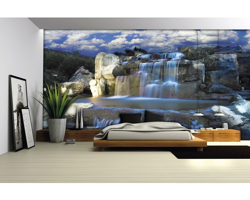 Wohnzimmer mit Fototapete Wasserfall-Motiv, Bett und Zimmerpflanze