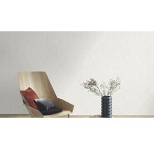 Wohnzimmer mit einer weißen Relief-Tapete, einem Holzstuhl und einem Tisch mit Blumen