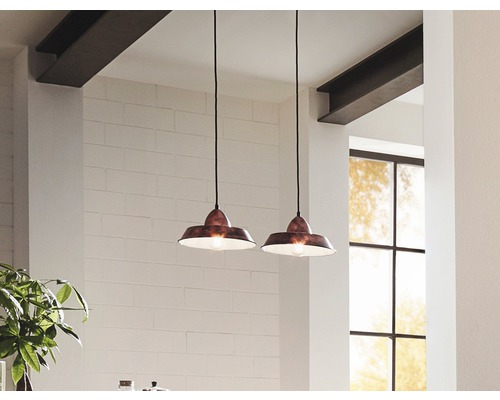 Zwei Pendelleuchten mit Lampenschirmen hängen in einem hellen Raum.