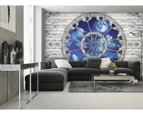 Wohnzimmer mit Sofa und einer Fototapete mit Fenster-Motiv auf einer Steinwand.