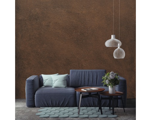 Wohnzimmer mit blauem Sofa, Couchtisch, Teppich und Pendelleuchten vor einer Wand